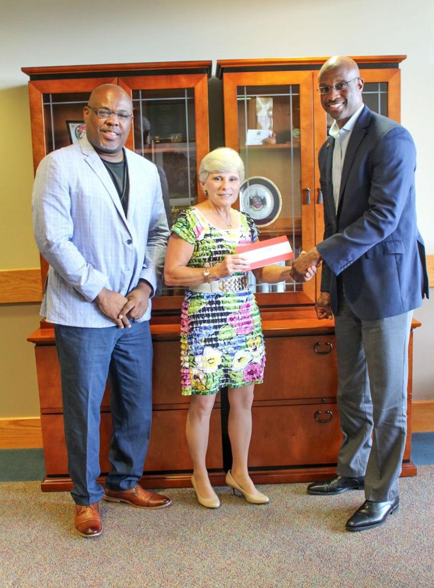 Alabama Power executives Terry Smiley, left, and Spencer Williams, right, present a $50,000 check to Dr. Kathy Murphy, president of Gadsden State