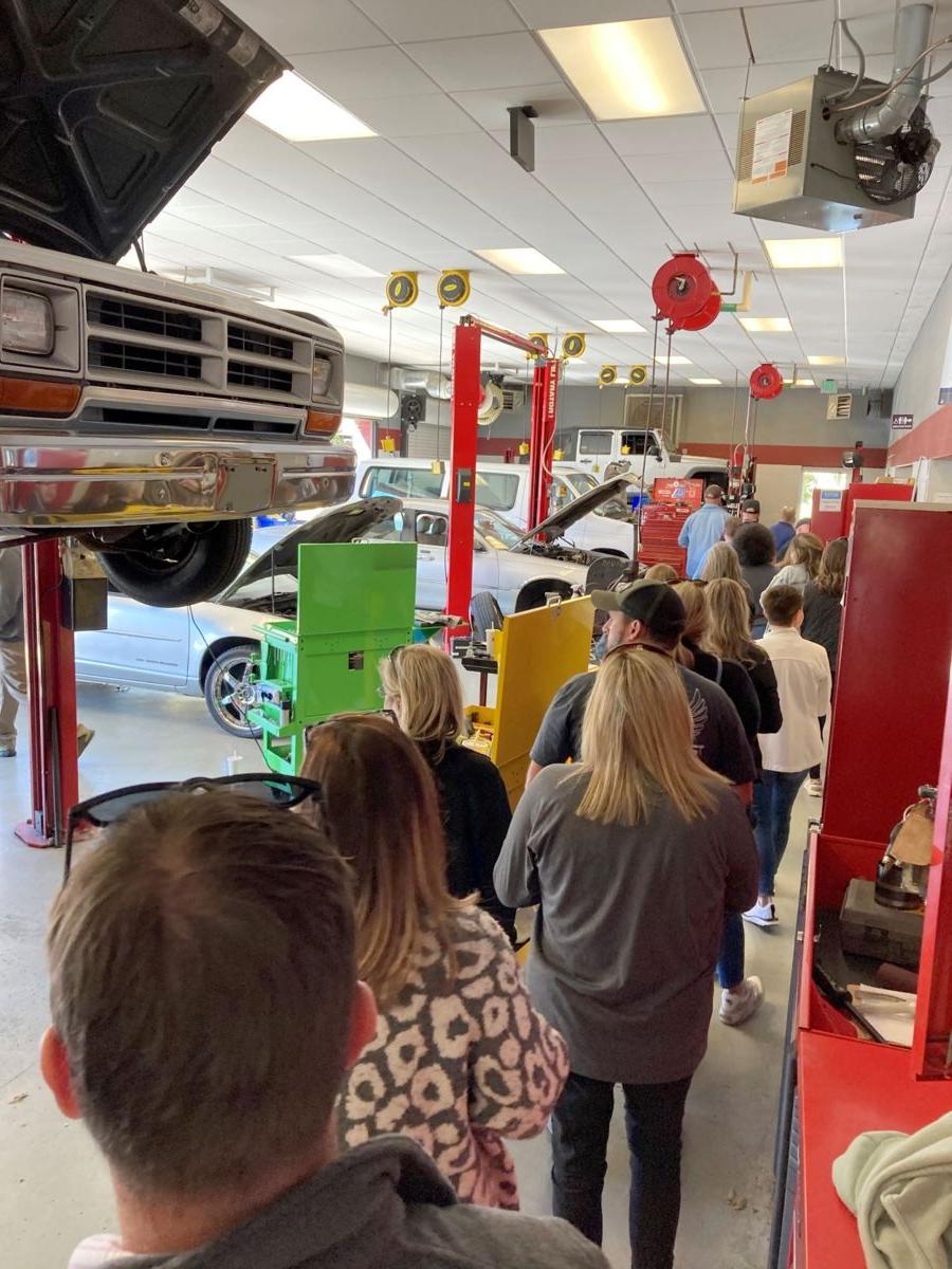 A group of educators participating in EQWIP walk through the h和s-on learning space in the Automotive Services Technology Program.